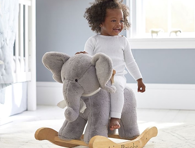 Smiling child on plush elephant rocker