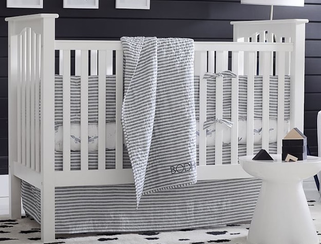 White crib with draped striped blanket