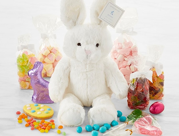 Easter bunny plushie surrounded by candy and chocolate