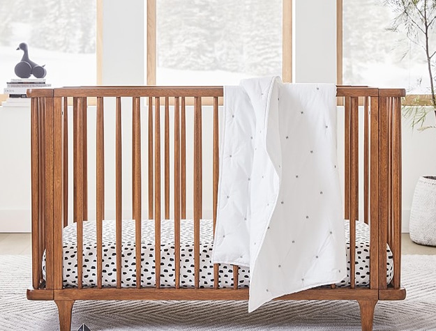 Wooden crib with polka dot sheets