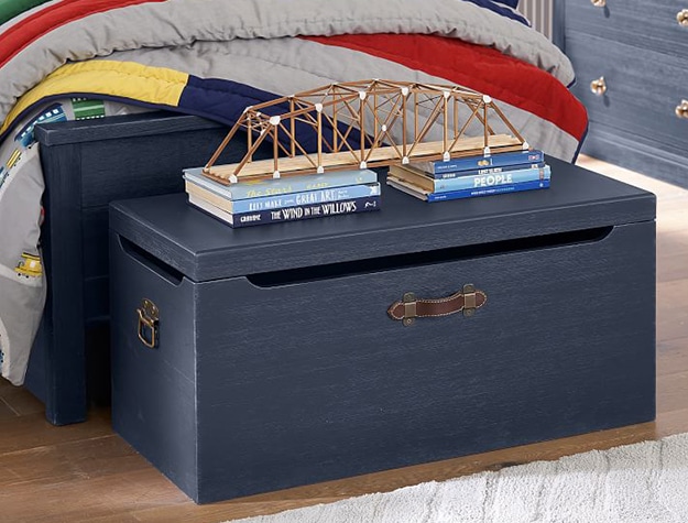 Navy toy box at the foot of kid’s bed