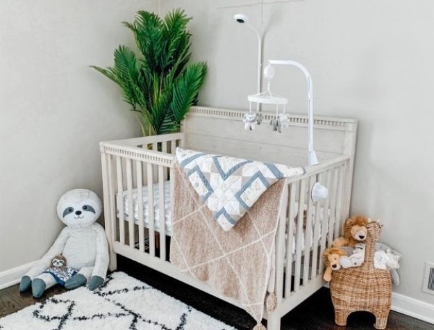 convertible crib with baby mobile and stuffed animals