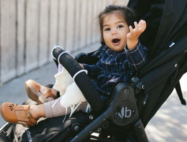 little girl playing with stroller accessories