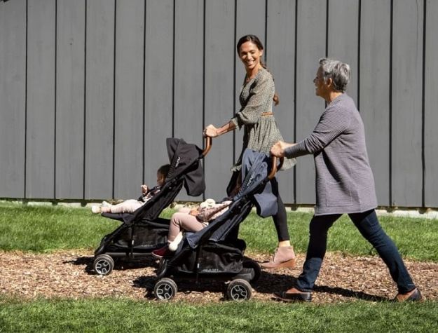 mother and grandmother pushing two jogging strollers