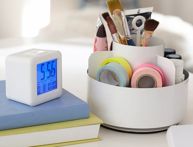 Metal lazy susan next to journal and clock