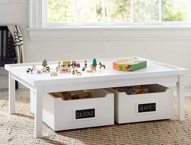 White toy table with white storage containers underneath 