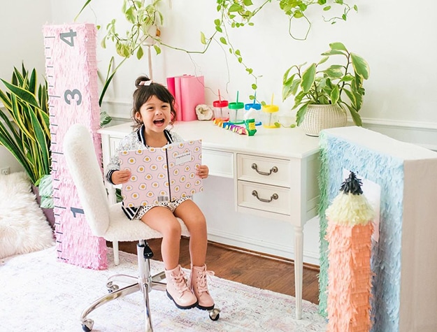 Happy child sitting at desk with ruler and pencil props