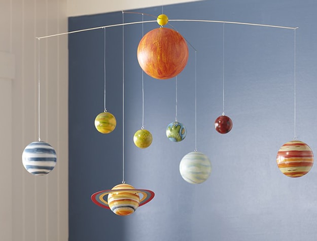 Two-toned kids room decorated with solar system mobile