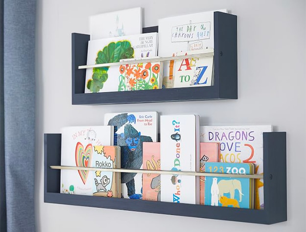 Navy wall shelves with baby books