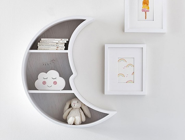 white moon shaped shelf and white picture frames