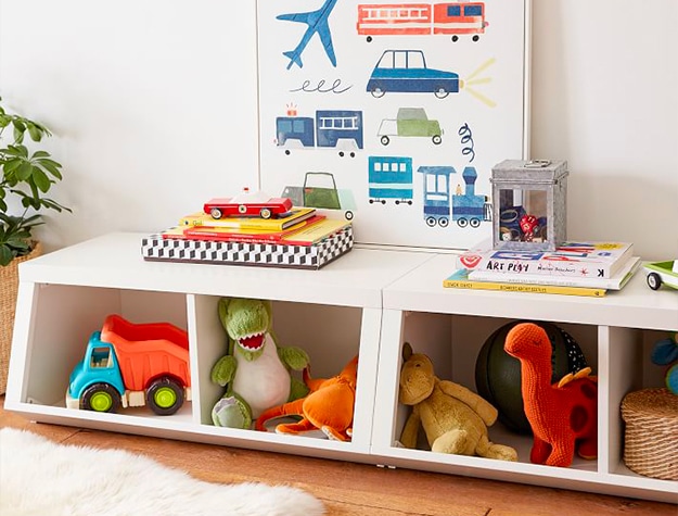 White toy bins storing stuffed animals and books
