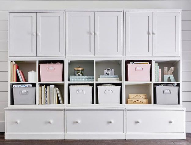 White wall storage unit with shelves and baskets