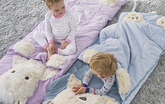 Blue and purple Shaggy hair puppy sleepy bag with young boy and girl smiling