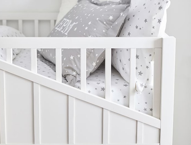 Close up of white bed with patterned sheets