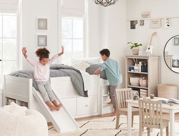 Children playing on bed with slide