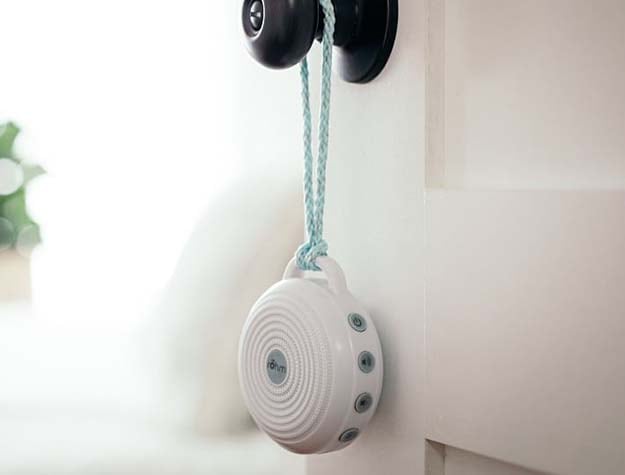A travel sound machine hanging from a doorknob