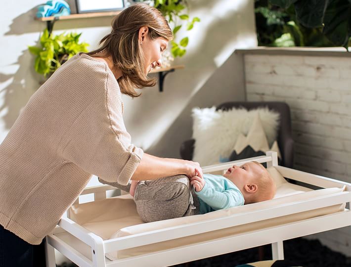 Mother changing baby on the Naturepedic Organic Cotton Changing Pad.