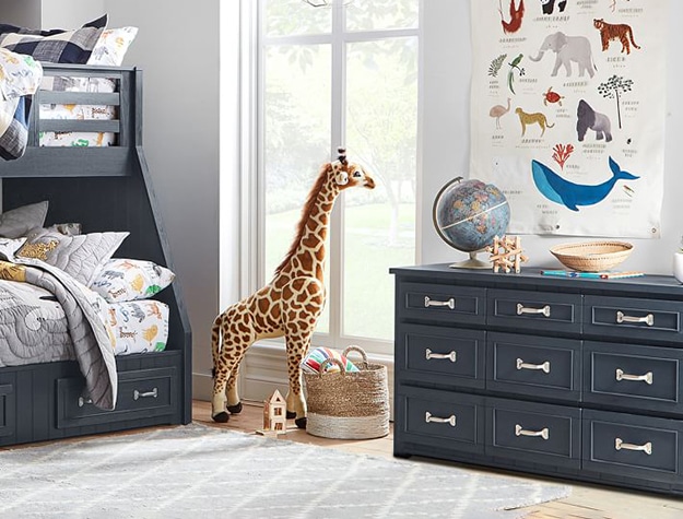 Kids bedroom with stuffed giraffe and extra wide dresser.