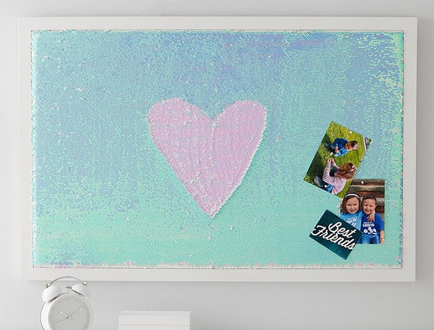 Flip Sequin Pinboard with pink heart in the middle of it.