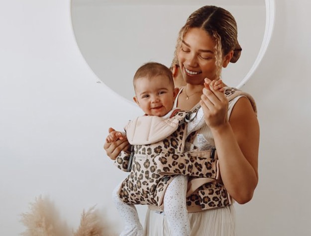 Mother holding baby in BABYBJÖRN® baby carrier.