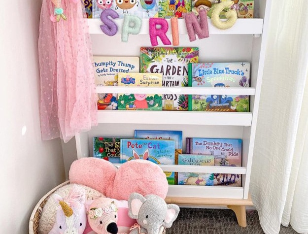 Sloan modern bookshelf displaying books and a string of felt letters spelling spring.