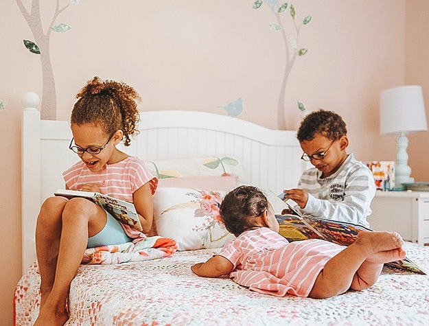 Three kids reading on a Catalina kids bed. 
