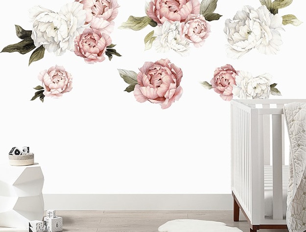 Urbanwalls blushing peonies wall decals behind crib in nursery. 