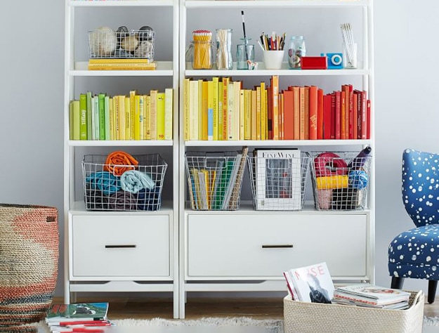 West Elm x pbk white Mid-Century Narrow Tower bookshelf with colored books and baskets.