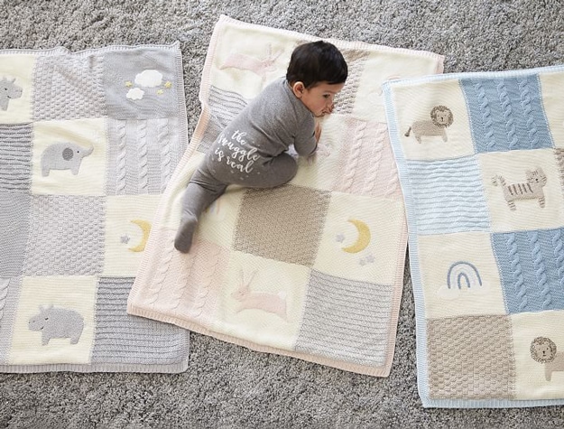 Heirloom Animals Baby Blanket Collection with a baby on top wearing a onesie that reads The snuggle is real.
