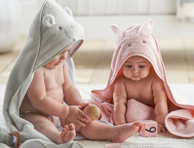 Two babies sitting and playing while wearing a Super Soft Animal Baby Hooded Towel & Washcloth Set.