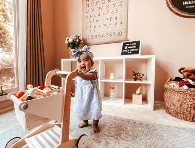 Toddler pushing cart filled with toys