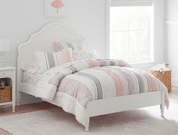 Twin sized Juliette Bed with striped pink sheets and pillows.