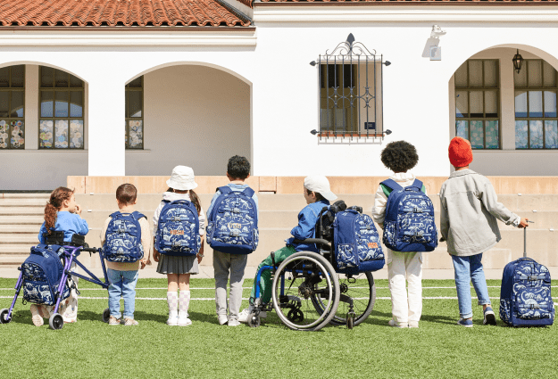 A photo of kids lined up by height to show backpack size and style range.