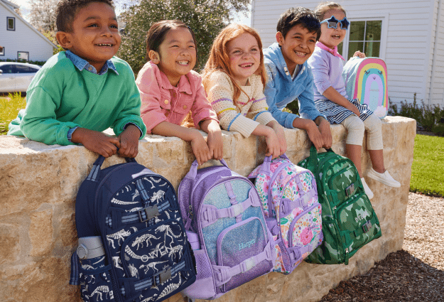 Kids posing with their backpacks, ready for the first day of school.