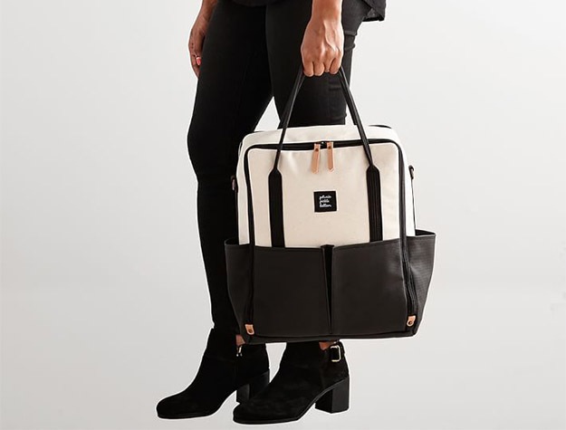 Woman holding Petunia Pickle Bottom Intermix Backpack.