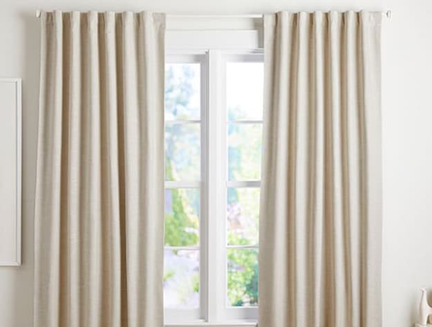 Beige linen blackout curtains in bedroom.